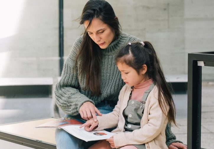 Woman living between cultures explaining something to her bicultural daughter