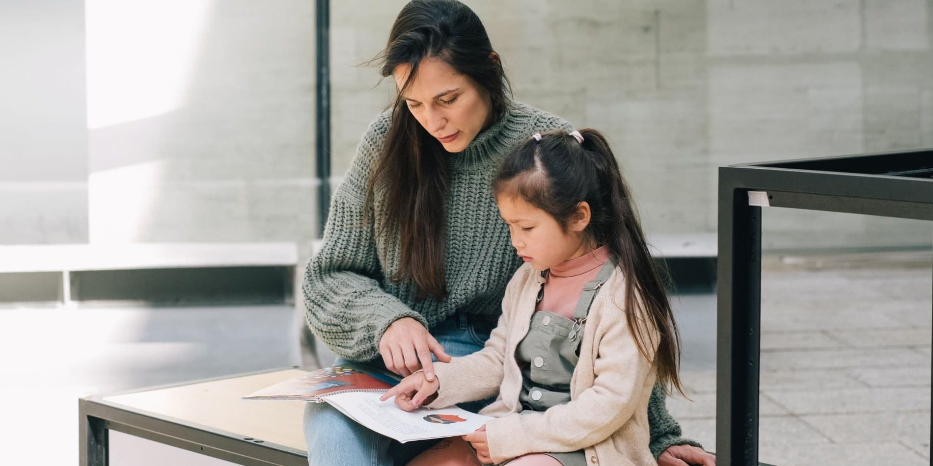 Woman living between cultures explaining something to her bicultural daughter