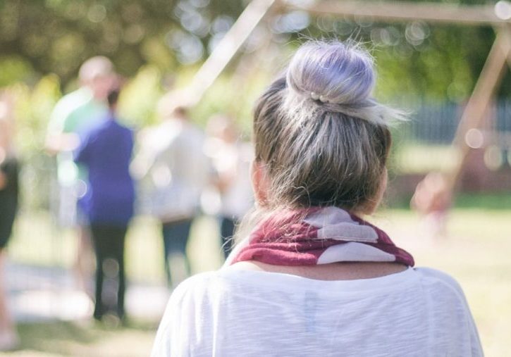 Woman living between cultures standing outside looking at people